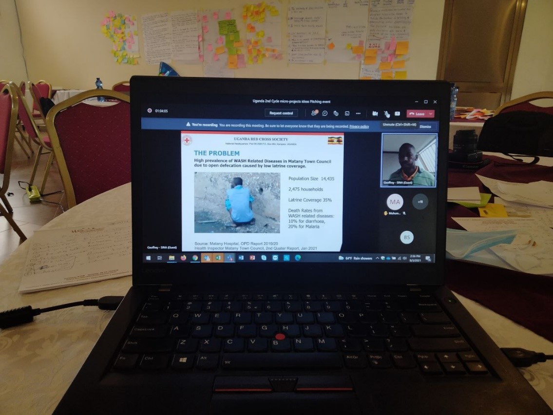 laptop on a table showing an online meeting with an ongoing presentation