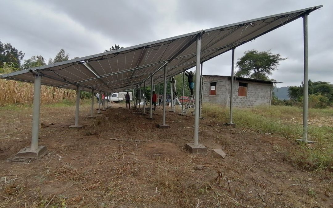 Image showing solar pannels on a field with a small house in the background